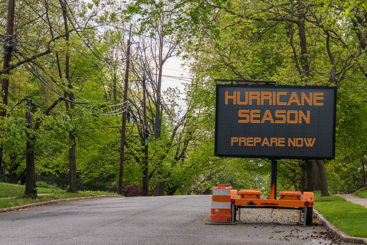 electric sign saying "hurricane season" on a forest road
