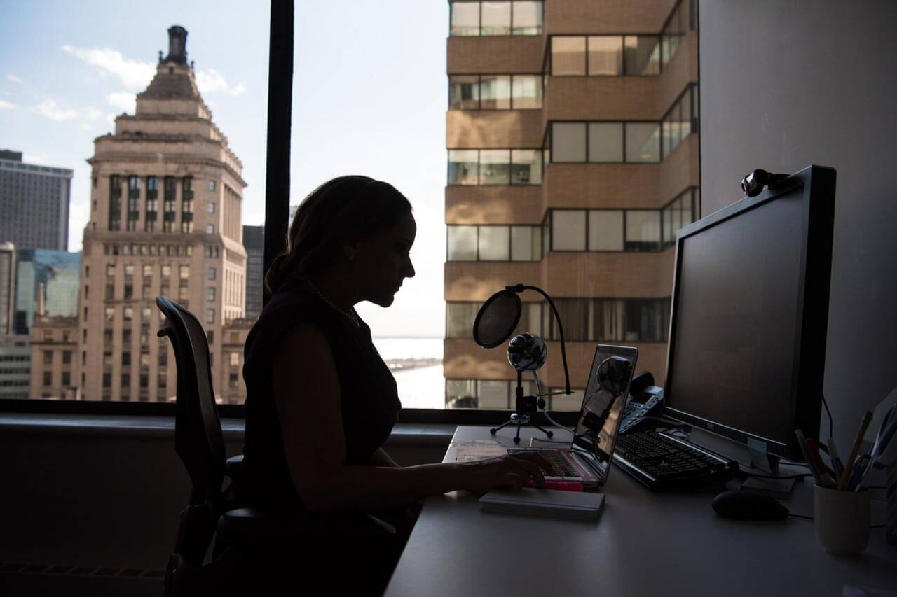 silhouette of a woman at he office desk in a big city