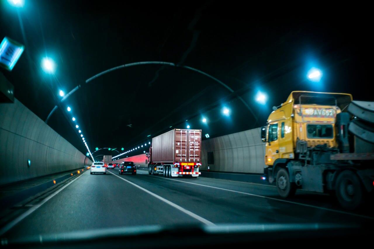 semi trucks in traffic within a road tunnel