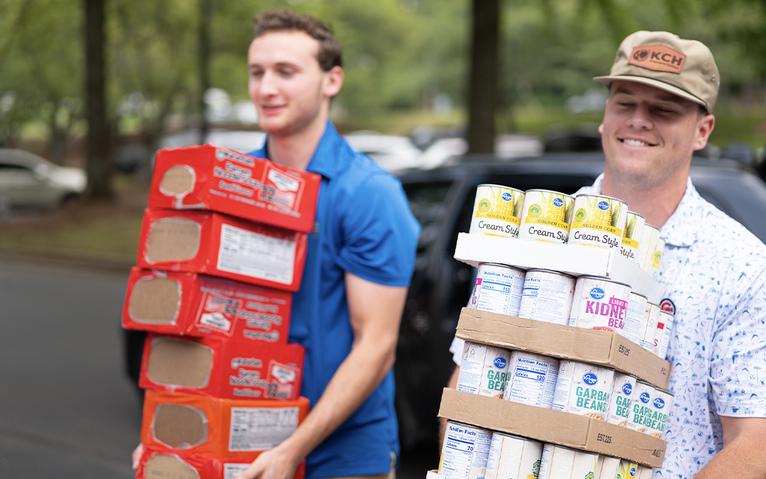 men carrying canned goods for kch cares