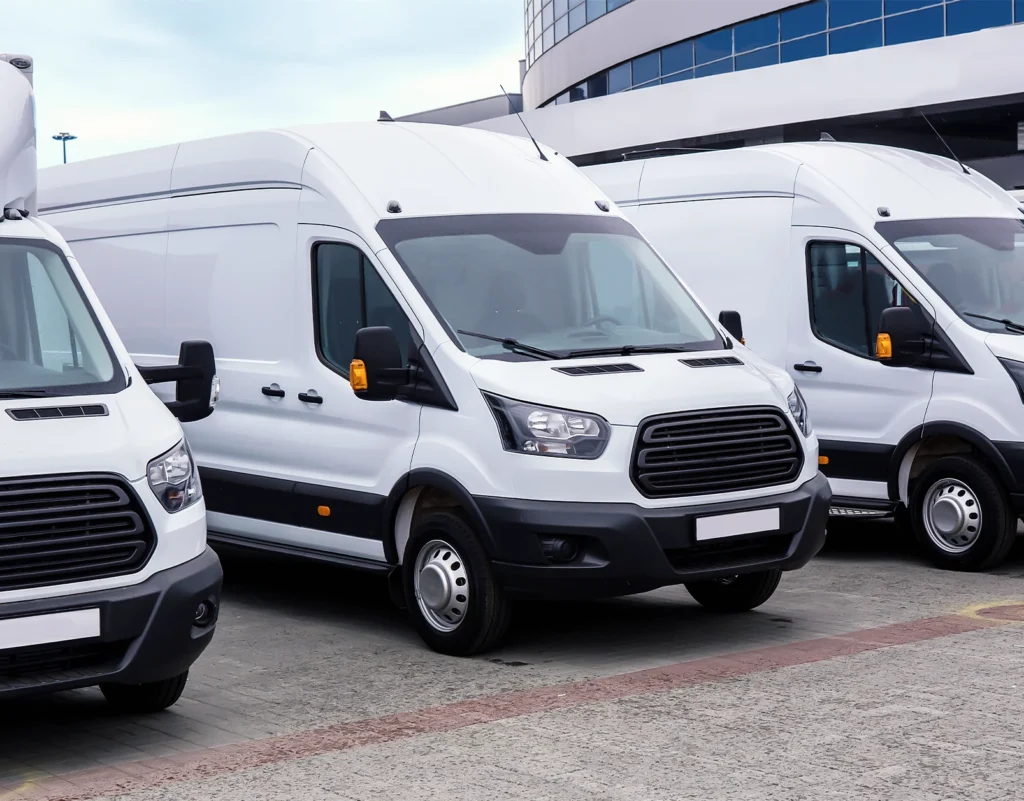 A fleet of sprinter vans sit parked in anticipation of being loaded for delivery.