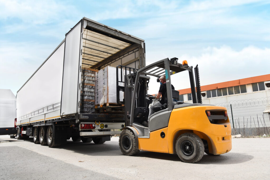 A forklift loads pallets onto a truck